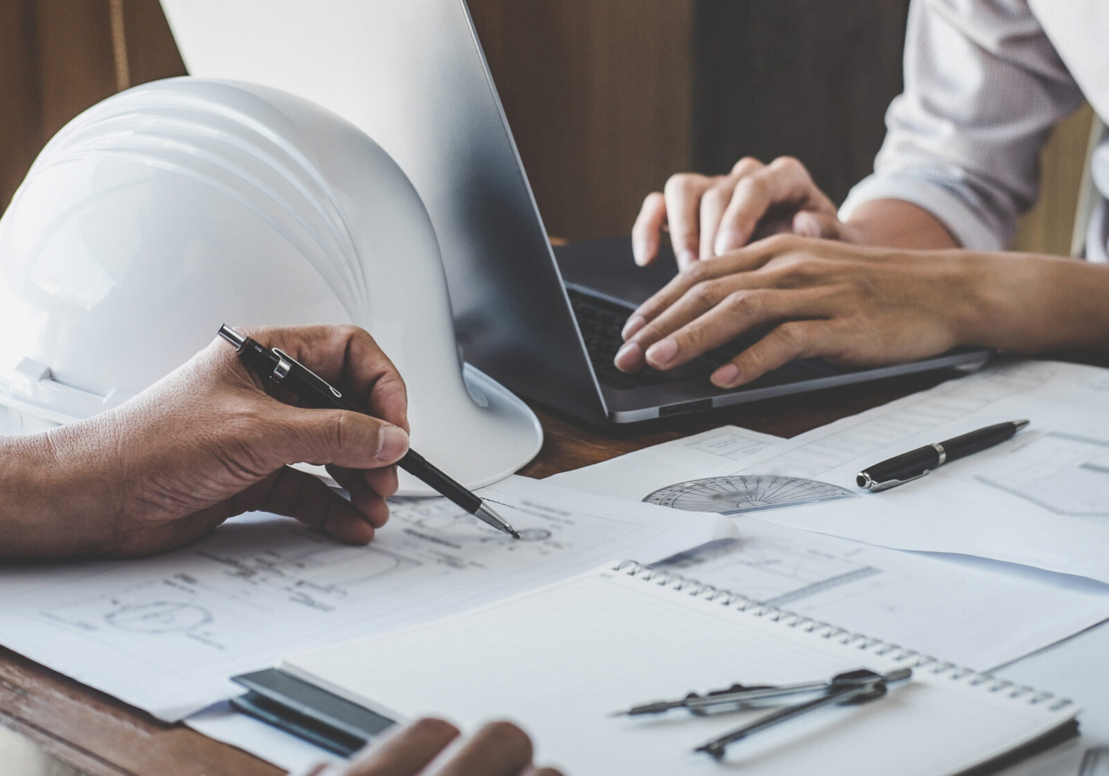 Construction and structure concept of engineer working drawing on blueprint meeting for project working with partner on model building and engineering tools in working site, construction concept.